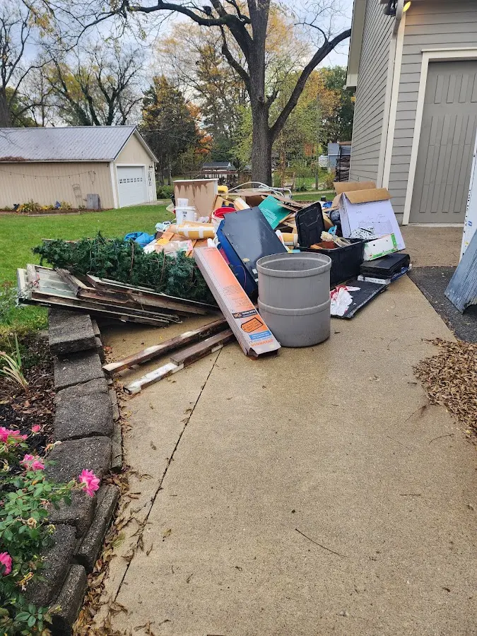 Dumpster being loaded with debris for Roofing Dumpster Rental in Grass Lake